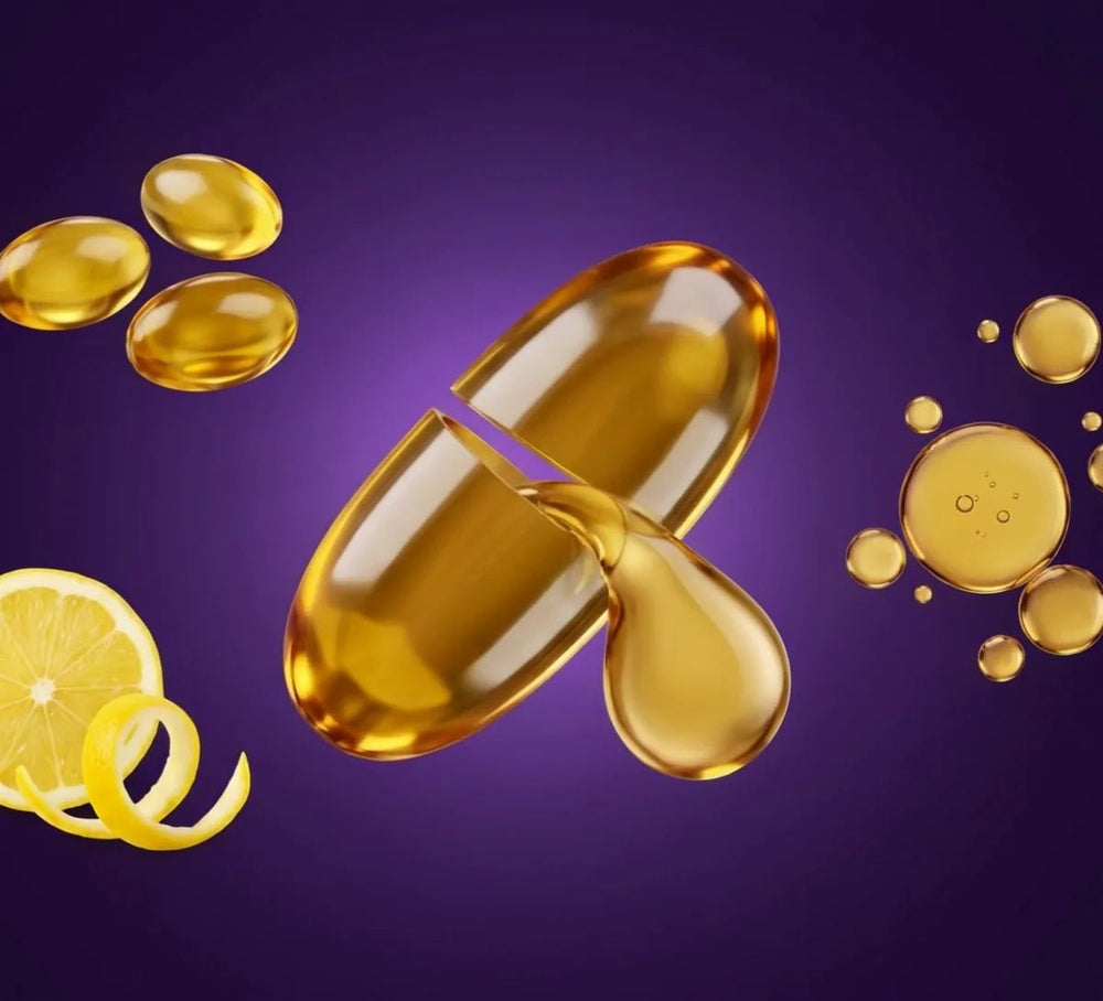 An Omega Sync softgel opening to release golden oil, with anchovies and a lemon slice