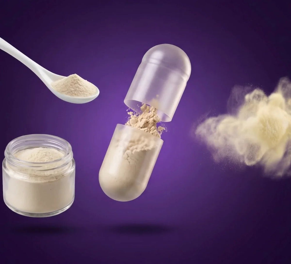 A Biome Balance capsule opened, with a porcelain spoon and a glass jar of probiotic powder and a soft cloud of powder