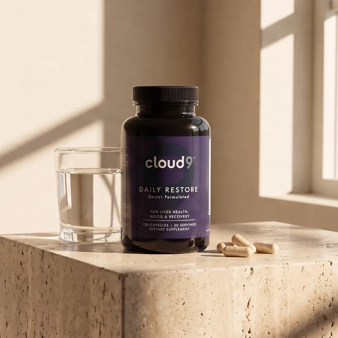A bottle of Daily Restore next to a glass of water and four capsules