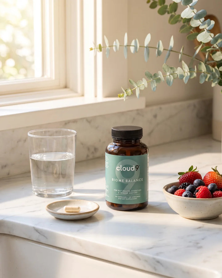 Biome Balance on a sunlit kitchen counter with a glass of water and berries